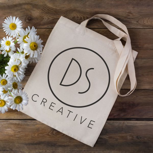 An image of a rustic, eco-friendly tote bag. The DS Creative logo is printed on the side and the fabric is unprocessed.